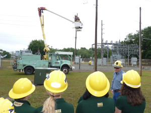 USF students observe a Tampa Electric lineman in action at the Skills Training Center.