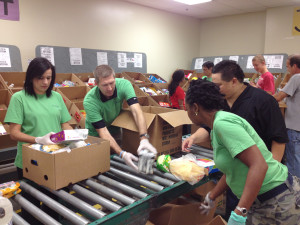 In their green Tampa Electric CommUnity T-shirts, company team members package food for Feeding America Tampa Bay.