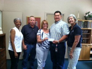 Laurie Kepler, second from left, accepts a check for $30,000 to the Mary & Martha House. With TECO, at far left, are Vivienne Davis beside David Hagelberg. Second from right is Ron Bishop beside Karen Zwolak. 