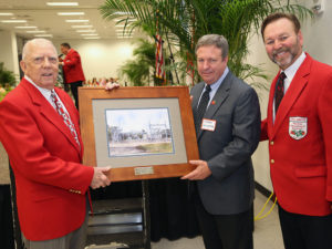Johnny Dean Page, Gordon Gillette and Doug Driggers, regional manager with TECO's Community Relations team, with the rendering of Johnny Dean Page Substation at the Florida Strawberry Festival Annual Parade Luncheon.