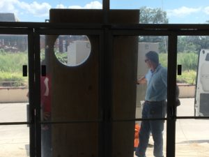 Members of TECO's Facilities Management team transform a customer door at the Tampa Greyhound Track into a temporary air conditioning vent to accommodate out-of-area crews.
